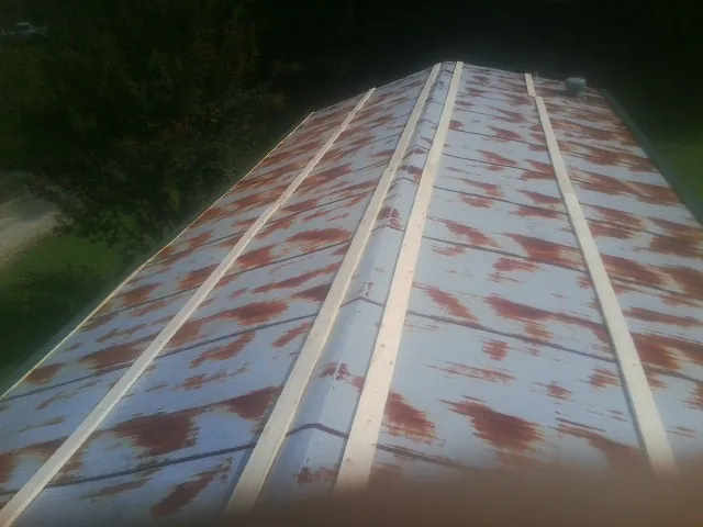 Rusted metal roof panels with new wood purlins before replacement — Storm Damage Roof Repair in Burtonsville by Roofing Brothers